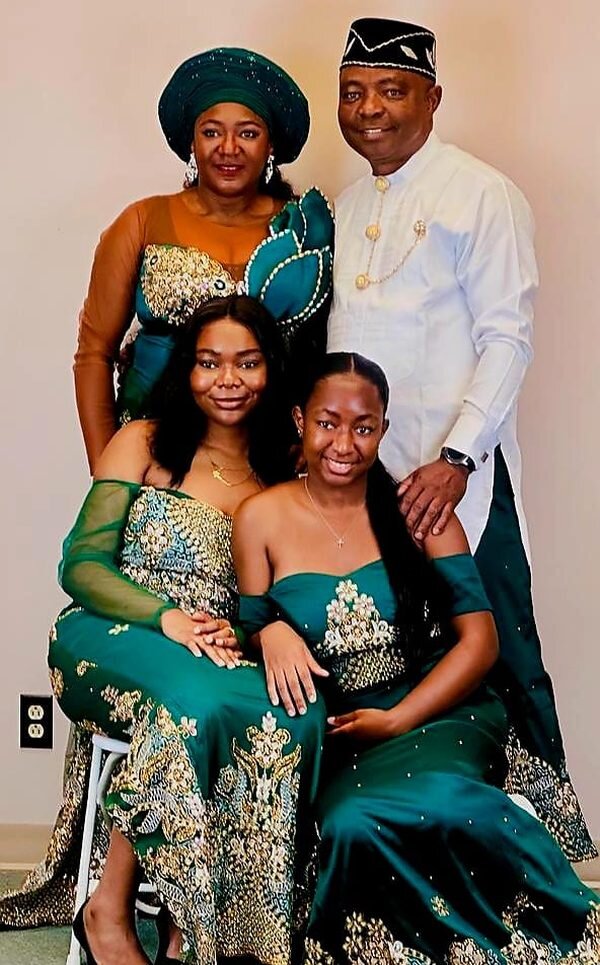 Dr. Victor Eghujovbo with his wife and daughters in green and gold traditional dress